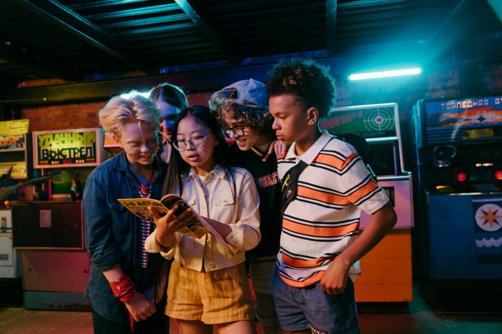 Group of diverse teenagers enjoying a retro arcade game, having fun indoors with friends.
